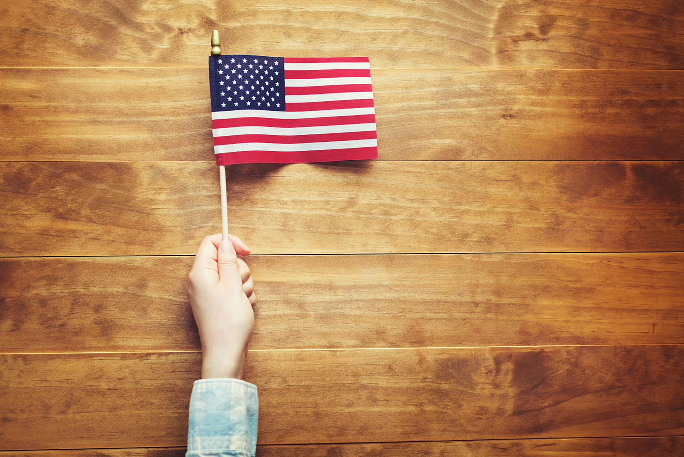 Hand holding up an American flag - for the Assembled in the USA blog post on Titanomachy's website